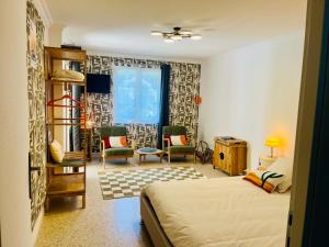 a bedroom with a bed and chairs in a room at Beau studio dans mas provençal in Avignon