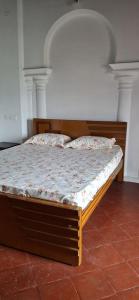 a bed in a bedroom with a wooden frame at Umbrella Guest House - Meenakshi Suite in Madurai