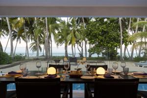 a table with wine glasses and a view of the ocean at Tenterfield Beachfront Luxury 4 Bedroom Holiday Home in Oak Beach