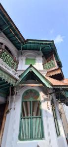 a building with a green door and a window at Umbrella Guest House - Meenakshi Suite in Madurai