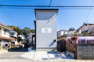 a white building with a door on a street at YAMAKATSU Hotel in Dazaifu