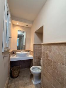 a bathroom with a sink and a toilet and a mirror at L' Appartamento Experience in Tivoli