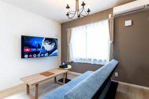 a living room with a blue couch and a table at YAMAKATSU Hotel in Dazaifu