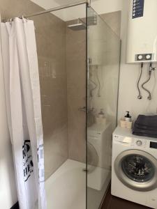 a shower in a bathroom with a washing machine at Lambertu ielas rezidence in Mārupe
