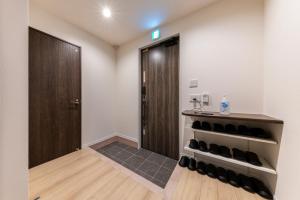 a room with a door and a shelf with wine bottles at YAMAKATSU Hotel in Dazaifu