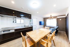 a kitchen and dining room with a wooden table and chairs at YAMAKATSU Hotel in Dazaifu