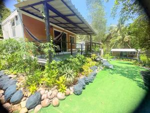 a house with a yard with grass and rocks at Moon Jungle Bungalows in Ban Madua Wan