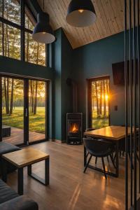 a living room with a table and a fireplace at Cieniówka, dom w lesie, Kije in Kije