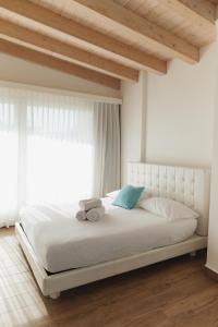 a bedroom with a bed with white sheets and a window at Villa Alcova in Caorle +128 photos