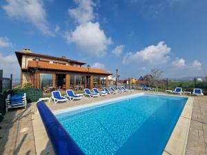 a swimming pool with lounge chairs and a house at Hotel Verdemar by Grupo A Cobijo in Lamadrid