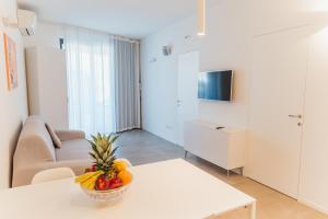 a living room with a table with a bowl of fruit at Villa Alcova in Caorle