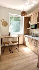a kitchen with a table and two stools and a window at Villa Antara in Szeged