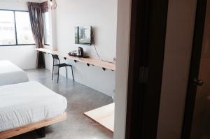 a bedroom with a bed and a desk in it at A3 Living in Suratthani