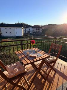 a wooden table with a vase of flowers on a balcony at Ladybug in Canale