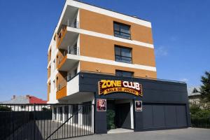 a building with a sign that reads zone club and a garage at Seranova Aparthotel 10 SELF CHECK-IN #Otopeni #Airport #Therme #Bucharest in Otopeni +3 photos