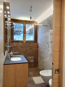 a bathroom with a sink and a toilet and a window at BORMIO Apartment AL PRADAIS in Bormio +116 photos