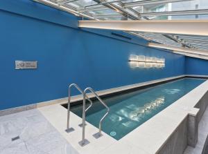 a swimming pool with blue walls and a blue wall at Sky Tower Serenity + Rooftop Pool in Auckland