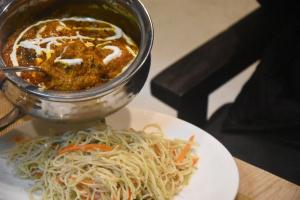 a plate of food with a bowl of soup and noodles at Shanti Regency in Guwahati