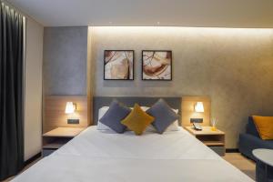 a bedroom with a bed with three pictures on the wall at Orchid parc in Bangalore