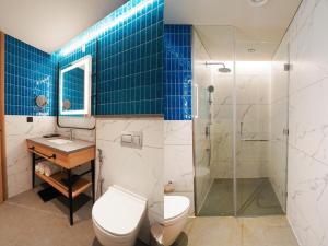 a bathroom with a toilet and a sink and a shower at Orchid parc in Bangalore