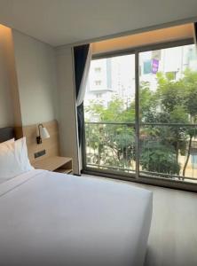 a bedroom with a bed and a large window at Orchid parc in Bangalore
