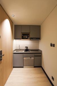 a small kitchen with a sink and a microwave at Orchid parc in Bangalore