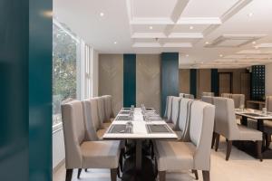 a dining room with a long table and chairs at Hotel HiStays, Dehradun in Dehradun