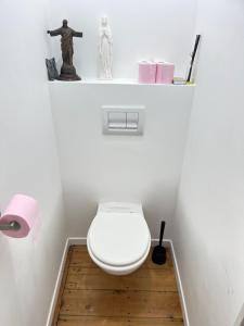 a bathroom with a toilet on a wooden floor at Petite chambre in La Madeleine