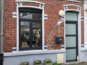 two windows on the side of a brick building at Petite chambre in La Madeleine