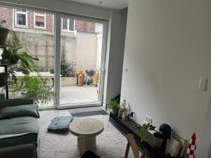 a living room with a couch and a sliding glass door at Petite chambre in La Madeleine