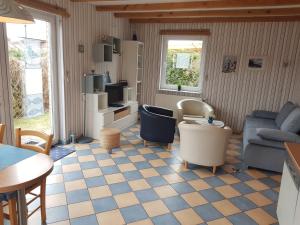 a living room with a couch and a table at Ferienhaus Undine, ruhige Lage, Nähe zur Altstadt, nur 500 m zur Müritz mit Strand, mit Parkplatz und Fahrradhäuschen in Waren