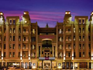 a large building with a car parked in front of it at Mercure Gold Hotel Jumeirah Dubai by Accor in Dubai