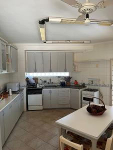 a kitchen with white cabinets and a table in it at Chacara Vila Bella in Bebedouro +12 photos