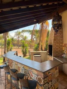 a kitchen with a bar with chairs and a patio at Chacara Vila Bella in Bebedouro