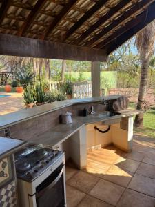 an outdoor kitchen with a sink and a stove at Chacara Vila Bella in Bebedouro