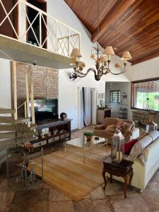 a living room with a couch and a tv at Chacara Vila Bella in Bebedouro