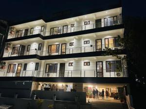 a large white building with people standing outside at night at Sukoon in Jāmb