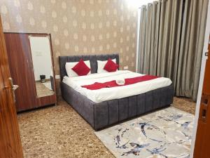 a bedroom with a bed with red pillows and a mirror at Sukoon in Jāmb