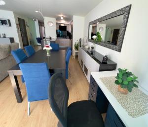 a kitchen and living room with a table and blue chairs at Casa Ponte do Mar in Sines +9 photos