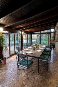 a large wooden table with green chairs in a patio at casa rural Ribera del Hueznar in Constantina