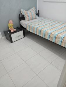 a bedroom with a bed and a white tiled floor at Maison au rez-de-chaussée à Mahdia rejiche in Mahdia