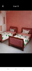 two beds sitting next to each other in a room at Maison au rez-de-chaussée à Mahdia rejiche in Mahdia