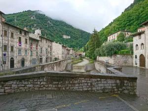 a street in a town with buildings and a mountain at Domus Calzolari in Gubbio