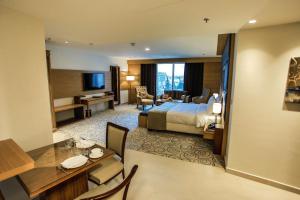 a hotel room with a king bed and a desk at Coral Tower Hotel by Hansa in Amman +76 photos