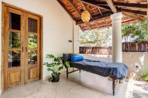 a bedroom with a bed and a wooden door at Casa Century Anjuna in Anjuna