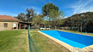 a blue swimming pool in the yard of a house at casa rural Ribera del Hueznar in Constantina