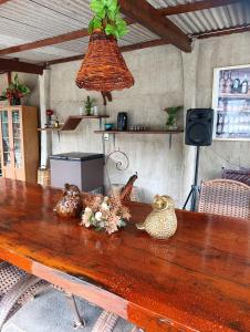 a wooden table with flowers on top of it at Chalés Crismel in Viçosa do Ceará