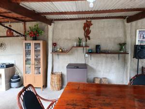 a dining room with a table and a refrigerator at Chalés Crismel in Viçosa do Ceará