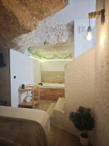 a bedroom with a bed and a tub in a room at Amonite in Alcalá del Júcar