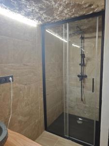 a shower with a glass door in a bathroom at Amonite in Alcalá del Júcar +4 photos